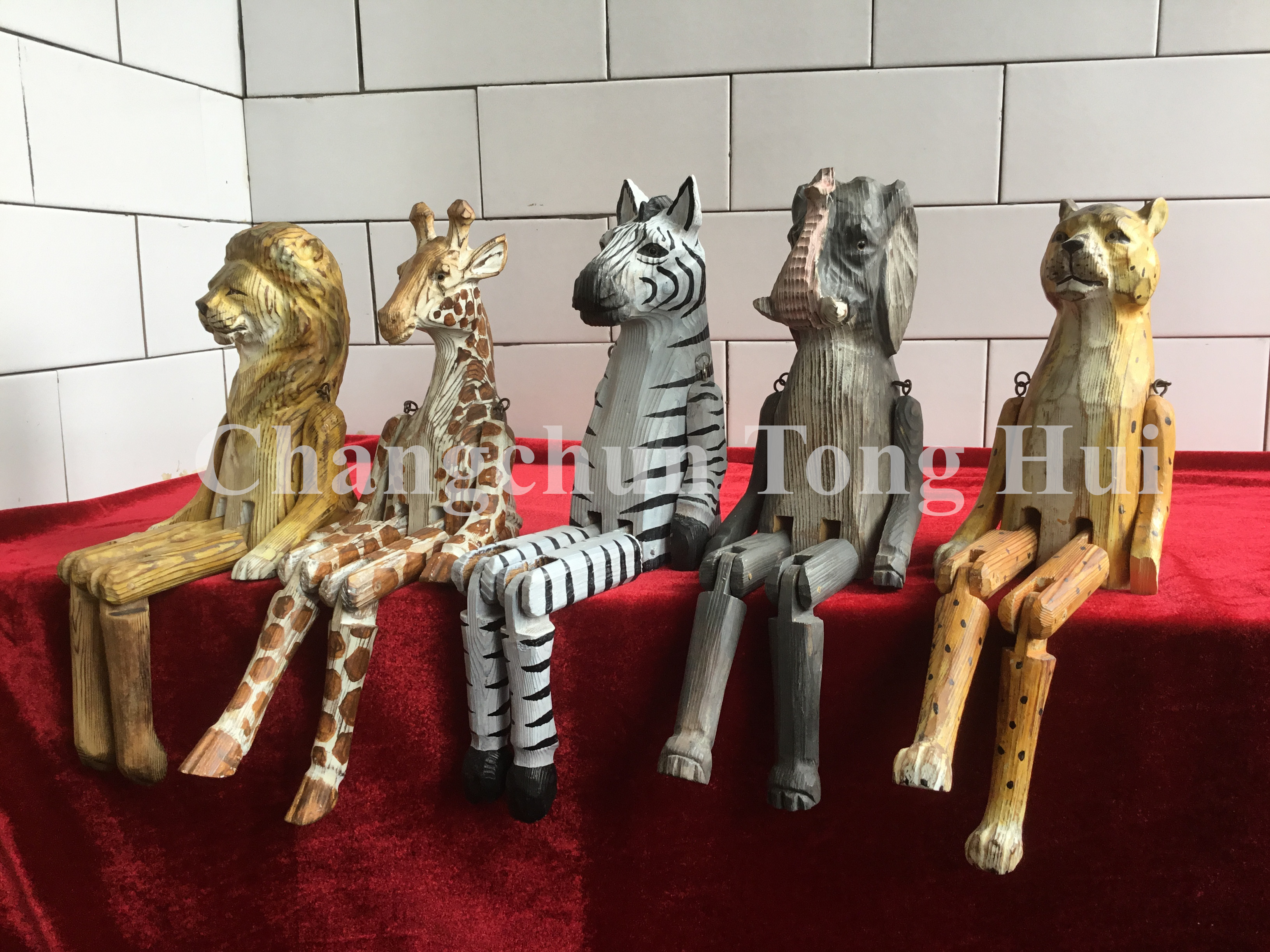 Wood carved sitting animal with dangly legs