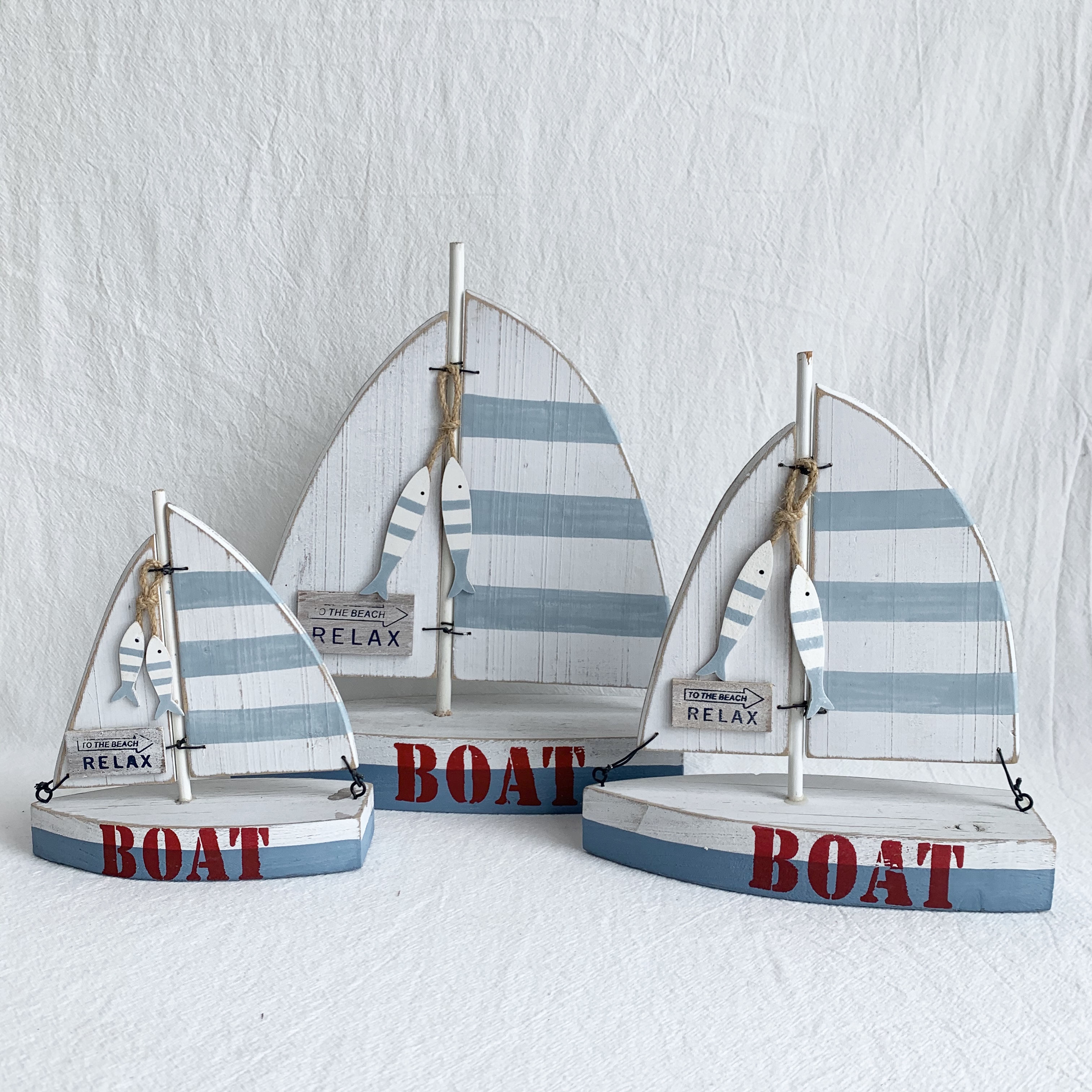 Wooden sailing boat with fish in light blue